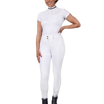 Mulher com camisa branca de manga curta e calças justas brancas com botas pretas