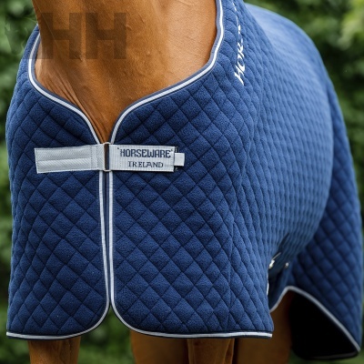 Cobertor de cavalo azul acolchoado com fecho frontal cinza e texto Horseware Ireland