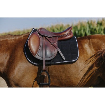 Sela castanha em pele sobre cavalo castanho com almofada preta acolchoada