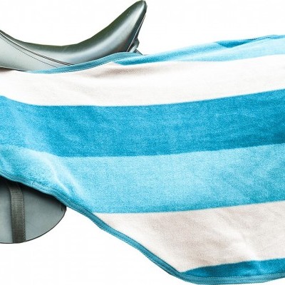Sela de equitação preta com toalha de praia azul e branca listrada