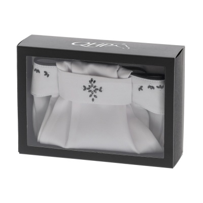 Caixa preta com saco branco decorado visível através de janela transparente