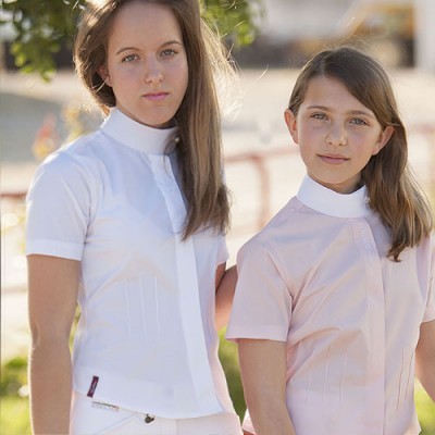 Camisolas de manga curta branca e rosa clara com gola alta usadas por duas crianças em ambiente externo