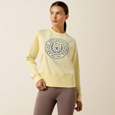 Mulher com sweatshirt amarela clara com padrão azul e leggings castanho claro