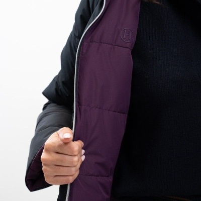 Casaco preto com forro roxo acolchoado e pessoa a abrir o casaco