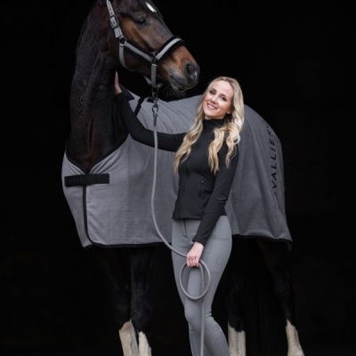 Pessoa com cavalo e manta cinza em fundo preto