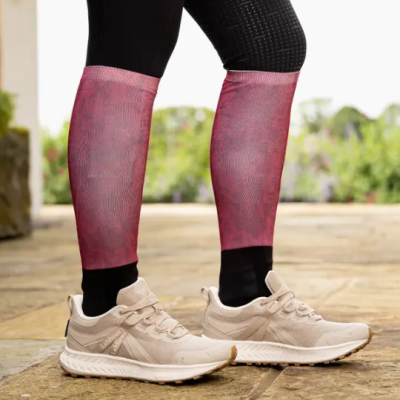 Pernas com leggings pretas, meias vermelhas compridas e sapatilhas desportivas bege claras