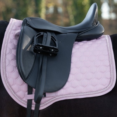 Selim de equitação preto sobre manta matelassê rosa em cavalo preto