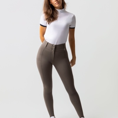 Mulher vestindo polo branca, leggings cinzentas e ténis brancos