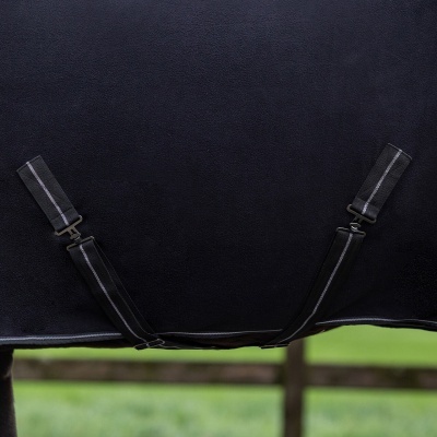 Cobertura preta para cavalo com correias elásticas pretas e fundo de relvado