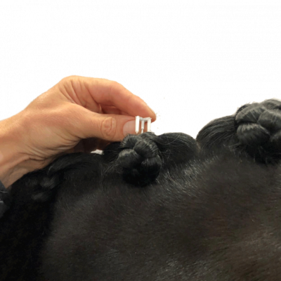 Gancho branco de plástico a prender cabelo preto com tranças