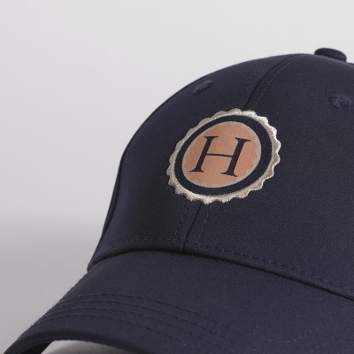 Boné preto com emblema circular castanho e bege com letra H