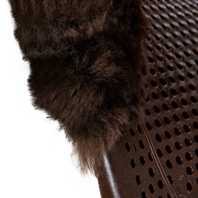 Manta ou tapete felpudo castanho sobre superfície marrom perfurada