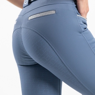 Calças azuis justas com bolso prateado e cinto de tecido entrelaçado