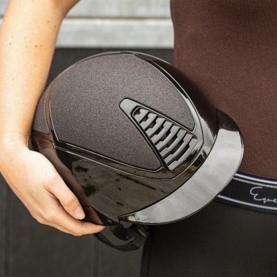 Capacete de equitação preto com detalhes em textura e grelha em mãos