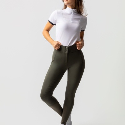 Mulher a usar calças justas verdes e t-shirt branca com gola subida e ténis brancos