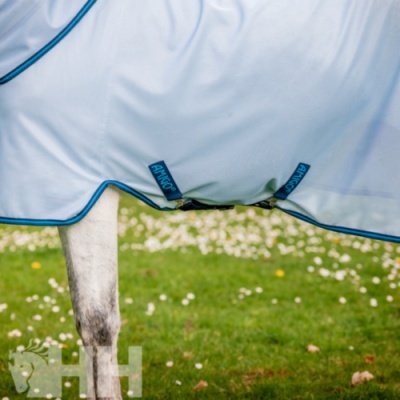 Manta branca para cavalo com bordas azuis e etiquetas HINCO junto à perna do cavalo