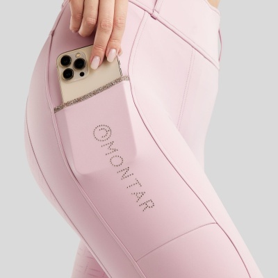 Calças de treino rosa com bolso lateral e texto GIVONITAR em strass, movimento de mão a colocar telemóvel no bolso.