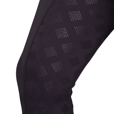 Perna com roupa preta texturizada com padrão de quadrados perfurados