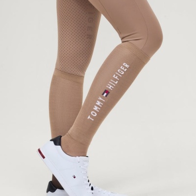 Calças bege com texto Tommy Hilfiger e ténis brancos com detalhes pretos e vermelhos