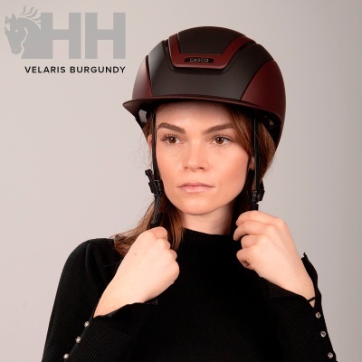 Capacete de equitação negro e burgundy usado por mulher com fundo cinza