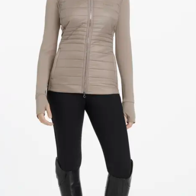 Casaco bege com fecho zip, calças pretas e botas pretas