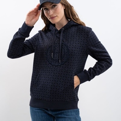 Modelo com sweatshirt azul escuro com padrão e logótipo, boné azul escuro e calças de ganga azuis