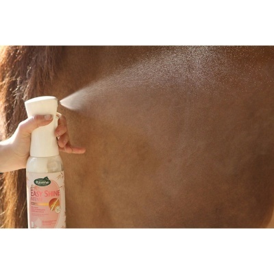 Frasco de spray Ravene Easy Shine a ser aplicado no pelo de um cavalo castanho claro