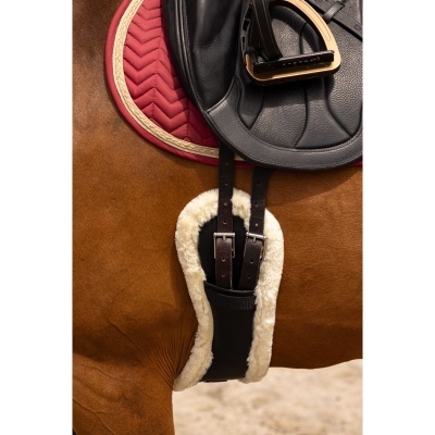 Sela preta em cavalo castanho com manta vermelha e alforje felpudo