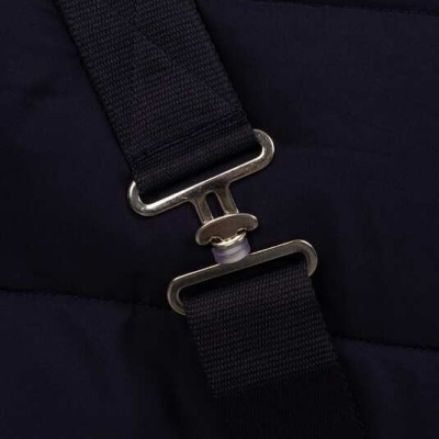 Correia preta com fecho metálico prateado sobre tecido acolchoado preto