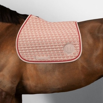 Manta de sela bege com padrão vermelho em cavalo castanho
