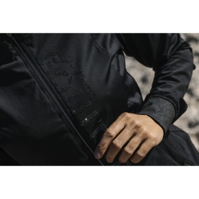 Casaco preto com fecho e texto embutido 'ROUTE' em tecido brilhante com mão direita pousada