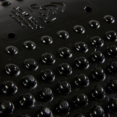 Superfície preta texturizada com relevos arredondados e hexagonais e texto LIXIL em relevo