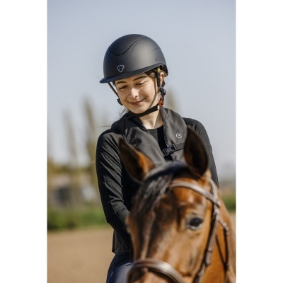 Mulher com capacete preto montada num cavalo castanho