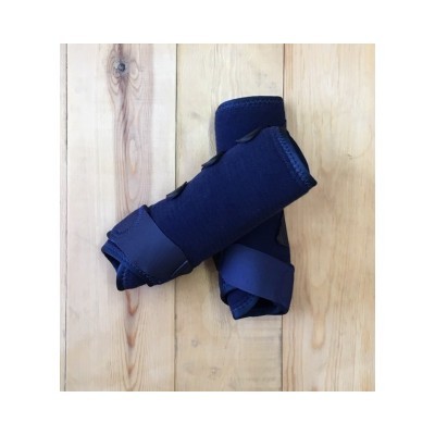 Braçadeiras ou suportes de compressão para antebraço em tecido azul escuro sobre piso de madeira.