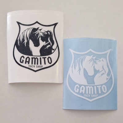 Dois autocolantes com logo 'GAMITO TACK SHOP' mostrando cabeça de cavalo e pessoa, um em branco com impressão preta e outro azul claro com impressão branca.