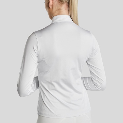 Mulher de costas com blusa branca de manga comprida e gola alta