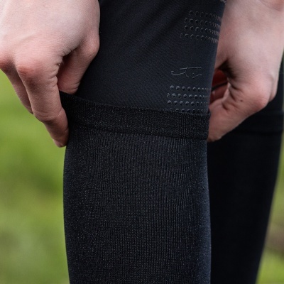 Pessoa a vestir meia preta e legging preta com detalhes texturizados