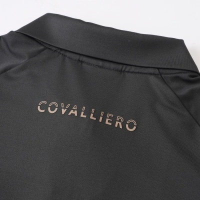 Detalhe de peça de roupa preta com gola e texto COVALLIERO nas costas