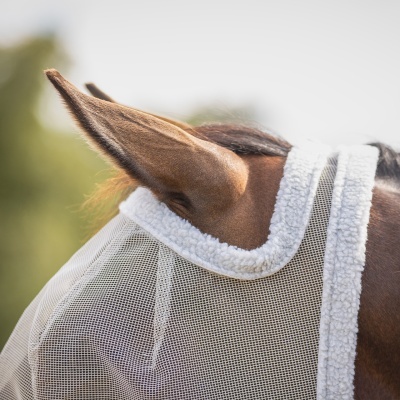 Máscara de malha branca com bordas felpudas sobre a cabeça de cavalo castanho