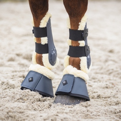 Proteções cinza com pelúcia bege para patas de cavalo em areia