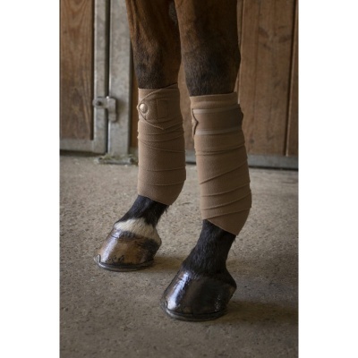 Botas de proteção bege para patas dianteiras de cavalo em estábulo de madeira