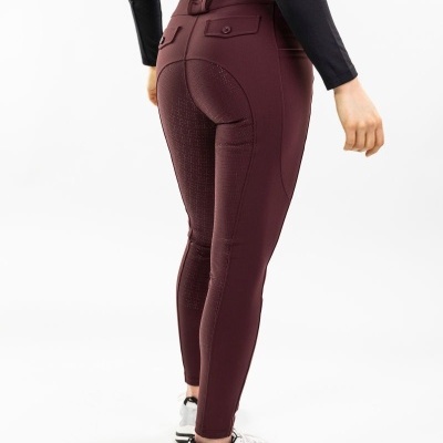 Calças justas bordeaux com textura antiderrapante e bolsos, usadas com camisa preta e sapatilhas brancas