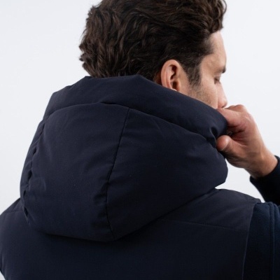 Colete azul escuro acolchoado com capuz visto de costas e perfil