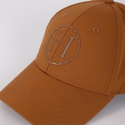 Boné castanho com bordado de letras H e H dentro de círculo ondulado