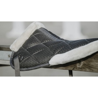 Pantufas acolchoadas cinza com interior felpudo branco sobre madeira