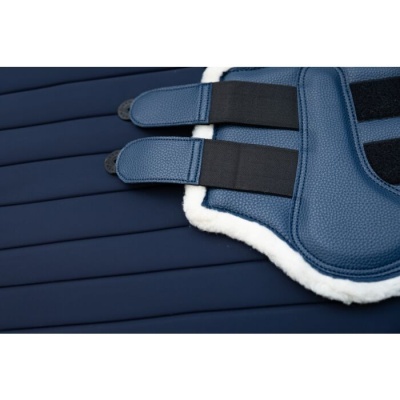 Equipamento azul com fechos de velcro e borda branca felpuda sobre almofada azul