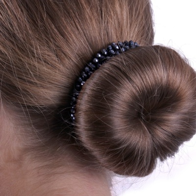 Tiara preta com contas brilhantes a prender um coque castanho claro