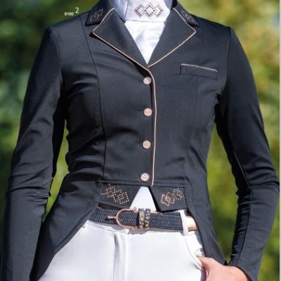 Mulher com casaco de equitação preto, camisa branca de gola alta e calças brancas em ambiente exterior