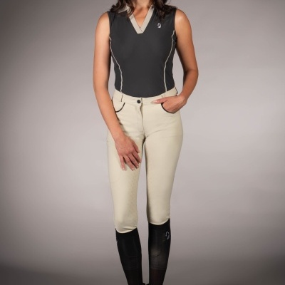 Mulher com roupa de equitação preta e bege em fundo cinza