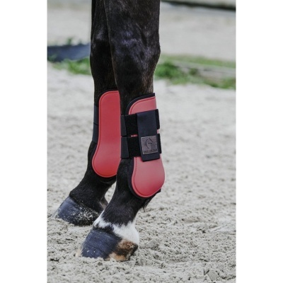 Perneiras vermelhas com velcro preto em patas de cavalo preto com manchas brancas